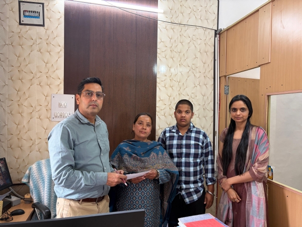 फोटोः प्रभावित परिवार को चेक सौंपते हुए शाखा प्रबंधक।