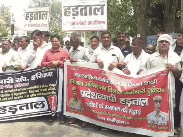फरीदाबाद में जुलूस निकालते कर्मचारी।