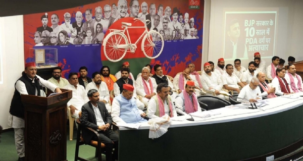 सपा अध्यक्ष अखिलेश यादव मंच से बोलते हुए और उपस्थित पार्टी नेतागण