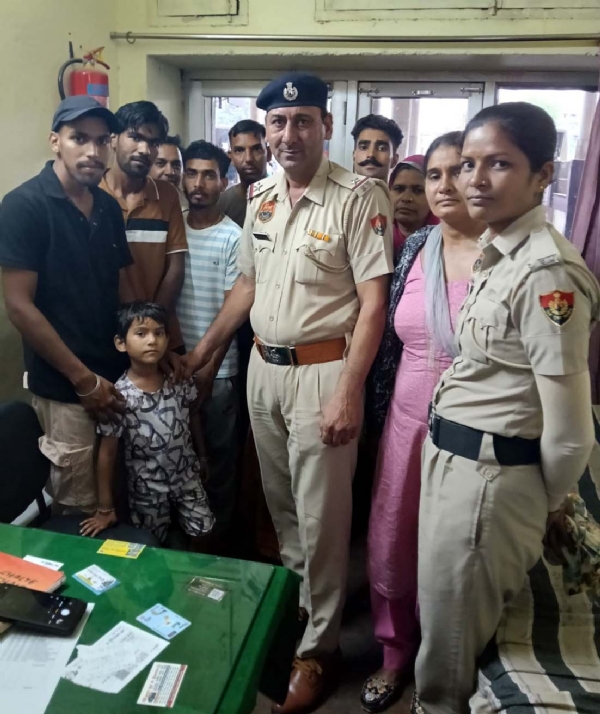 बच्ची को परिजनों के हवाले करते पुलिस कर्मचारी।