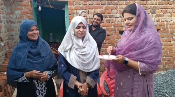 टॉपर राशिदा नाज को मिठाई खिलाती उसकी बड़ी बहन