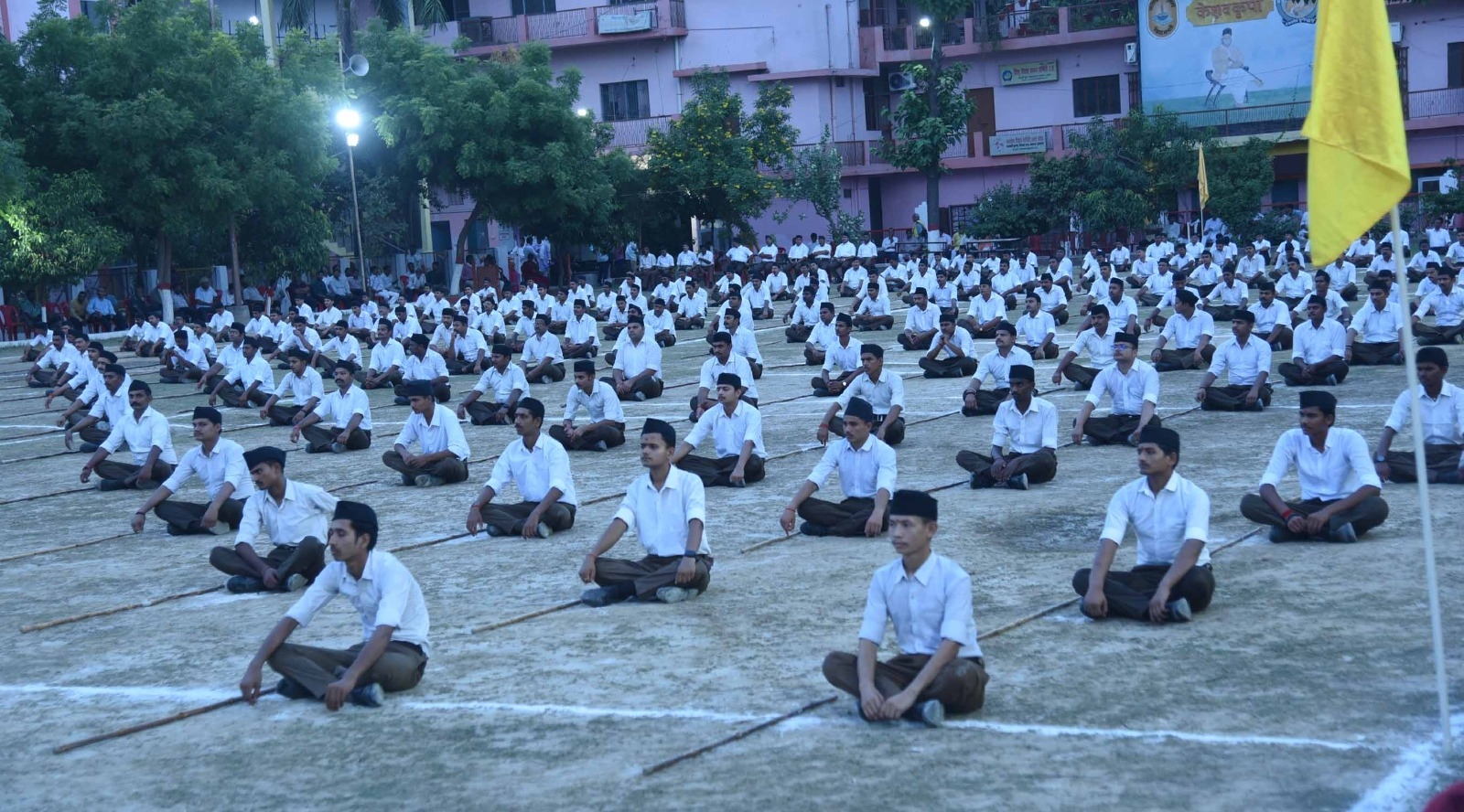 मैदान में बैठे स्वयंसेवक
