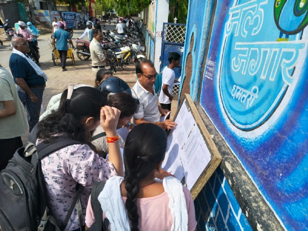 परीक्षा केंद्र के बाहर अपना रोल नंबर देखते हुए परीक्षार्थी। परीक्षा केंद्र के बाहर अपना रोल नंबर देखते हुए परीक्षार्थी।