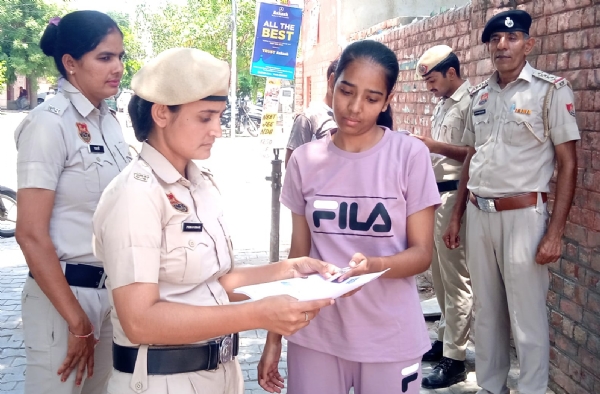 परीक्षा केंद्र में जाने से पहले परीक्षार्थियों की जांच करते हुए पुलिसकर्मी।