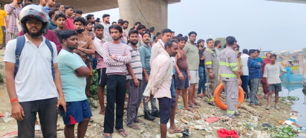 नदी किनारे घाट पर मौजूद लोग