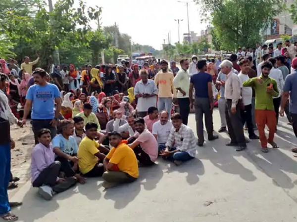 जाम के दौरान सड़क पर बैठे कर्मचारी व मजदूर ।
