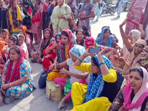 जाम के दौरान सड़क पर बैठी महिलाएं।