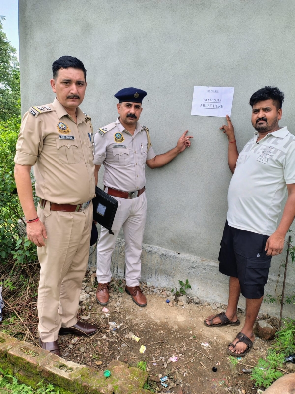 पोस्टर लगाते हुए पुलिस कर्मी। पोस्टर लगाते हुए पुलिस कर्मी।