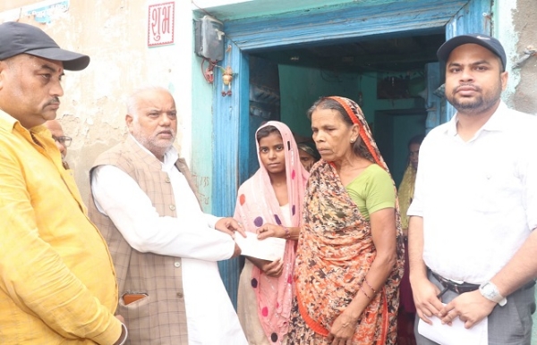 मंत्री श्रवण कुमार पीडि़त परिवार को मुआवजा राशि देते हुए