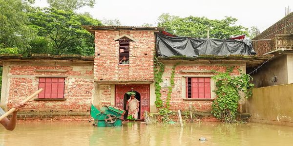 बांग्लादेश में सतकानिया उपज़िले के मोरिचयापारा में एक परिवार बाढ़ के पानी के बीच अपने घर में फँसा हुआ बांग्लादेश में सतकानिया उपज़िले के मोरिचयापारा में एक परिवार बाढ़ के पानी के बीच अपने घर में फँसा हुआ