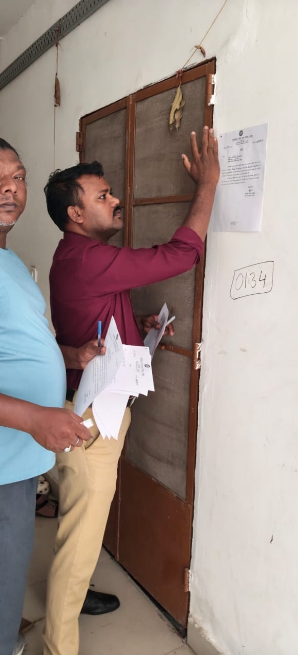 फ्लैट में नोटिस साटते हुए निगम के अधिकारियों की तस्वीर फ्लैट में नोटिस साटते हुए निगम के अधिकारियों की तस्वीर