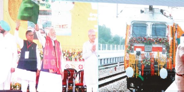 प्रधानमंत्री हरी झंडी दिखाकर ट्रेन को रवाना करते हुए