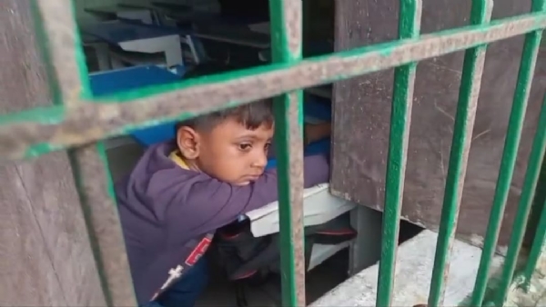 विद्यालय में बंद छात्र खिड़की से देखते हुए विद्यालय में बंद छात्र खिड़की से देखते हुए