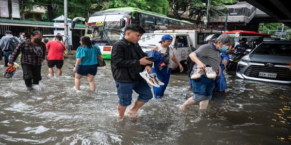 मनीला में भारी बारिश के बाद सड़क पर बाढ़ के पानी के बीच जाते लाेग मनीला में भारी बारिश के बाद सड़क पर बाढ़ के पानी के बीच जाते लाेग