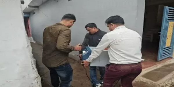नोट गिनने की मशीन ले जाते पुलिसकर्मी नोट गिनने की मशीन ले जाते पुलिसकर्मी
