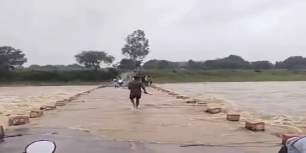 शहडोल: कुनुक नदी में जान जोखिम में डाल उफनते पुल पर बाइक से आवाजाही, तेज बहाव में लकड़ियां बटोरते दिखे